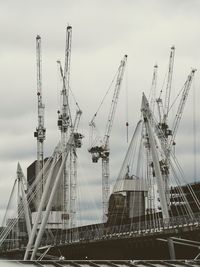 Cranes at construction site against sky