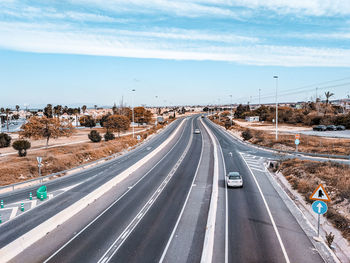 Vehicles on highway against sky