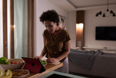 African american woman watching recipe online