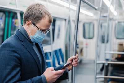 Businessman using phone while traveling in train