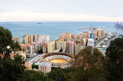 High angle view of buildings by sea against sky