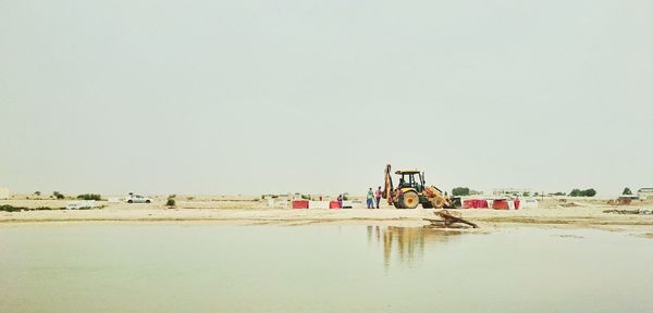 People on beach against clear sky