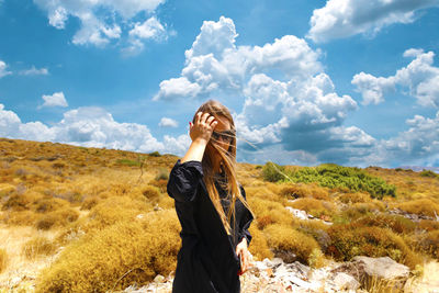 Woman standing on land against sky
