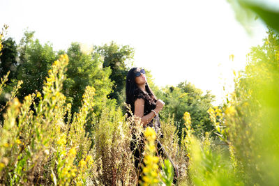 Young woman amidst plants on field