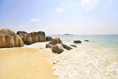 Rocks on beach against sky