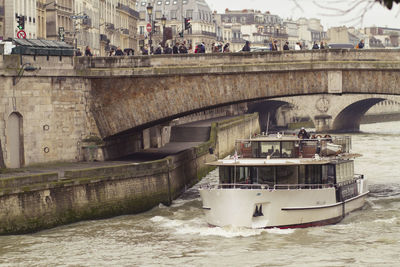 Passenger craft sailing on river in city