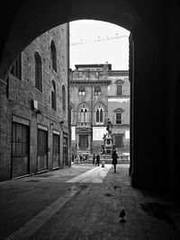 People walking on street amidst buildings in city