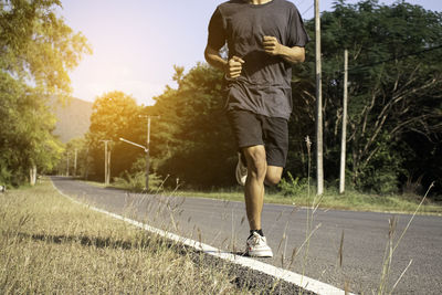 Rear view of boy with umbrella on road