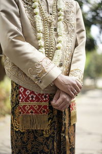 Midsection of woman standing against wall