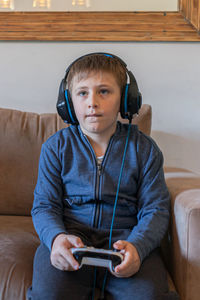 Full length of boy sitting on mobile phone