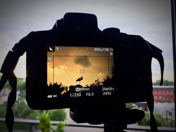 Close-up of silhouette person photographing against sky