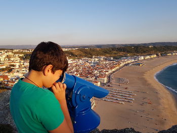 Man on beach against sky in city