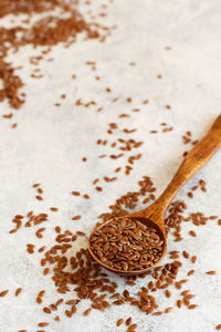 Raw flax seeds in a wooden spoon close up