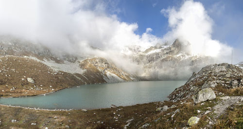 Scenic view of lake by mountains against sky