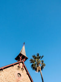 Low angle view of coconut palm tree against blue sky