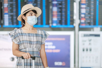 Woman wearing flu mask standing at airport