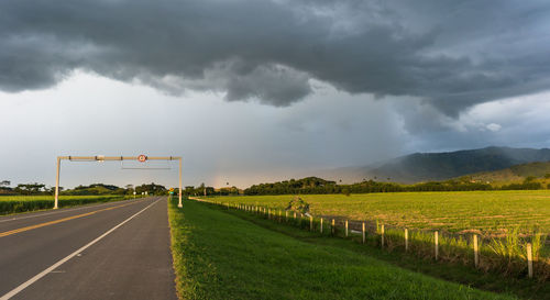 Road amidst field against sky