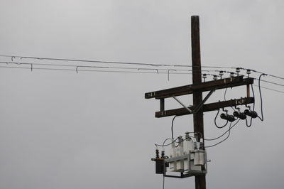 Low angle view of electricity pylon against clear sky