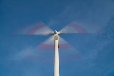 Low angle view of wind turbine against blue sky