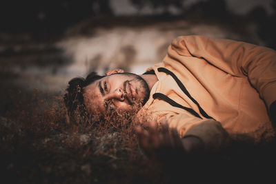 Portrait of young man lying outdoors