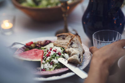 Cropped image of man having food at table during garden party