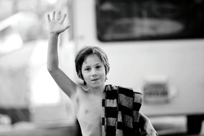 Portrait of young boy waving