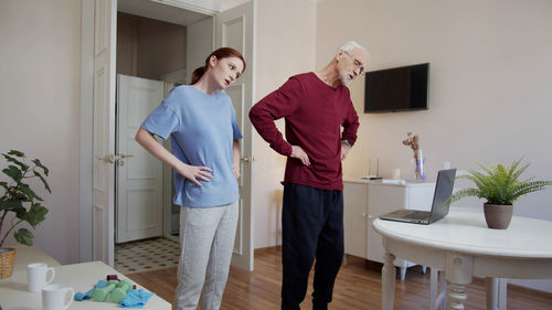 Side view of young man holding hands while standing in bathroom