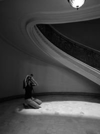 Young woman photographing illuminated ceiling light