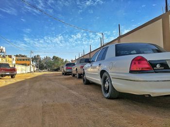 Cars on road against sky in city