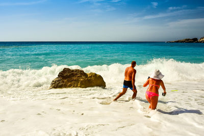 People at beach against sky