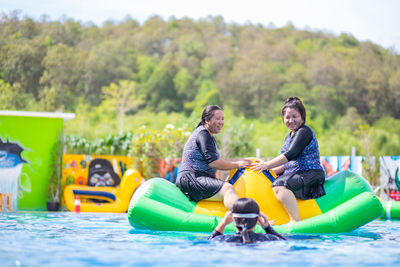 Smiling females on inflatable raft in sea