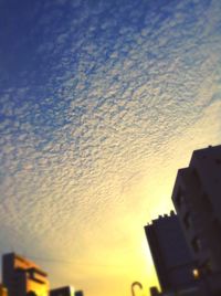 Low angle view of buildings against sky at sunset