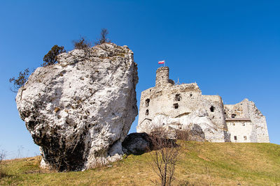 Low angle view of old building against clear blue sky