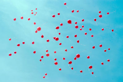 Low angle view of balloons flying against sky