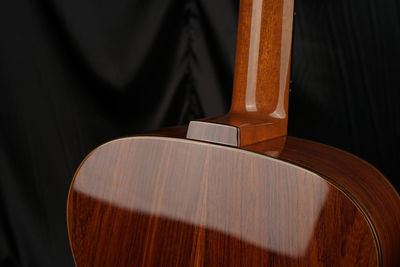 Close-up of acoustic guitar on bed