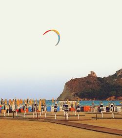 People on beach against clear sky