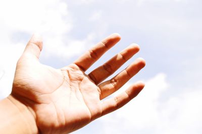 Cropped hand of man against sky