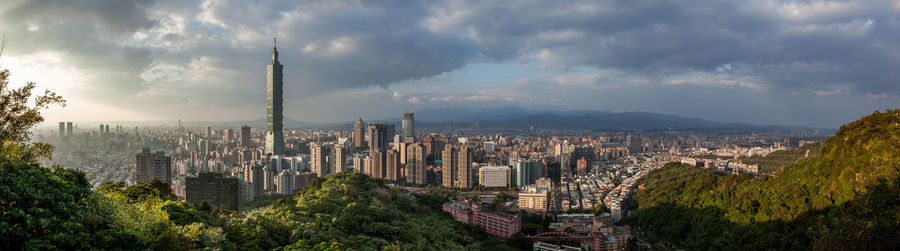 Panoramic view of city against cloudy sky