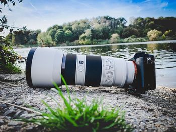 Close-up of camera by trees against sky