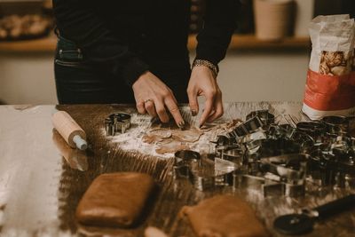 Midsection of woman preparing cookies on table