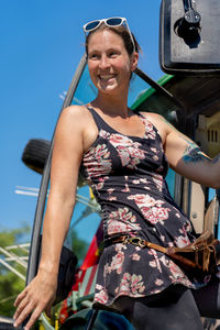 Smiling woman standing against sky