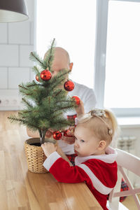 Portrait of boy playing with christmas tree at home