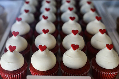 High angle view of cupcakes with whipped cream and heart shape candies