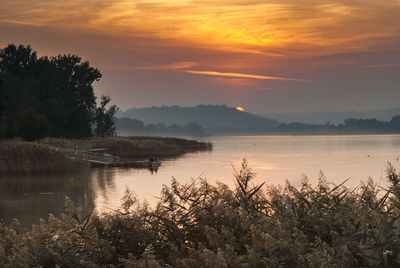 Scenic view of lake against orange sky