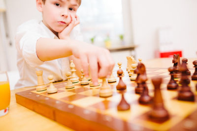 Full length of baby boy playing on chess board