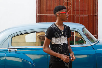 Boy standing by car