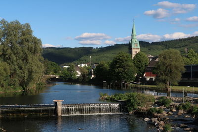 Scenic view of river and buildings against sky