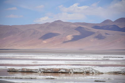 Scenic view of sea and mountains against sky