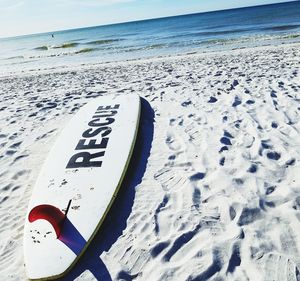 Text on sand at beach against sky