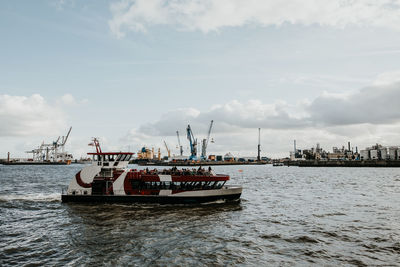 Fishing boat at harbor against sky